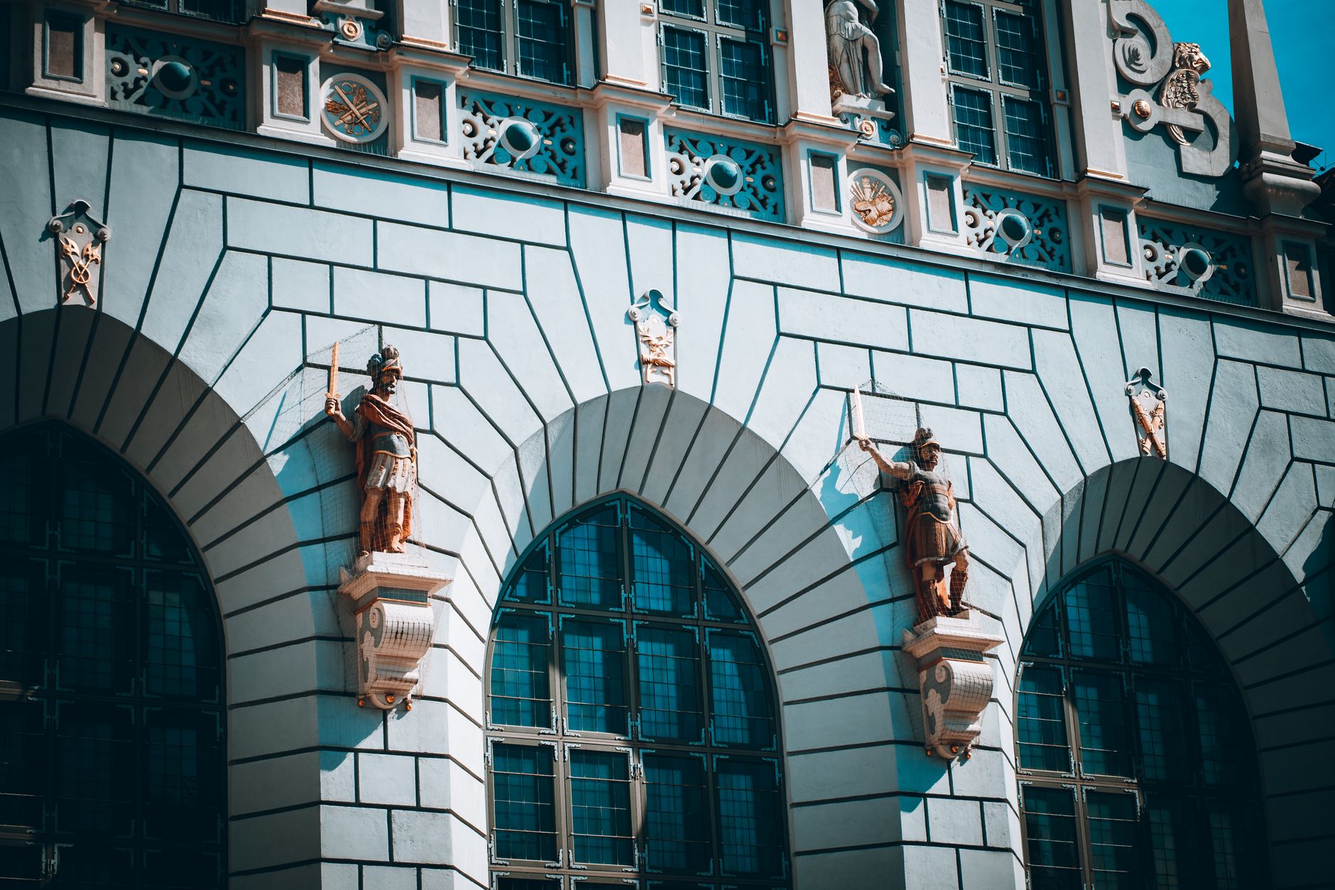 Intricate architectural facade with statues in Gdańsk, Poland, showcasing historic design elements. — Trójmiasto