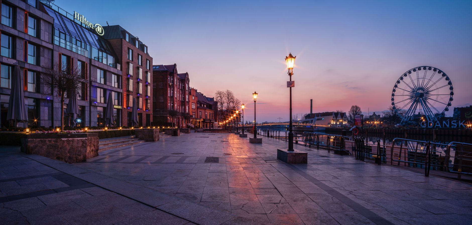 Scenic twilight view of Gdańsk waterfront featuring architecture and ferris wheel. — Trójmiasto