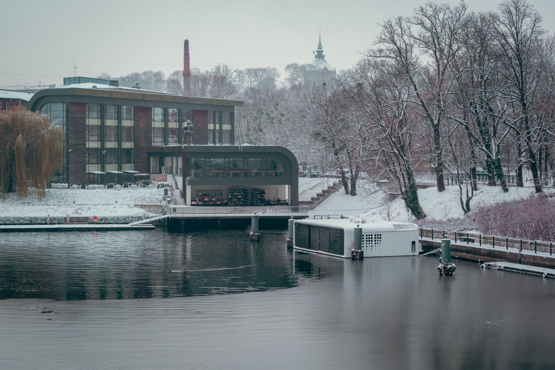 A serene winter view of Przystań Bydgoszcz along the snow-covered riverbank in Poland. — Trójmiasto