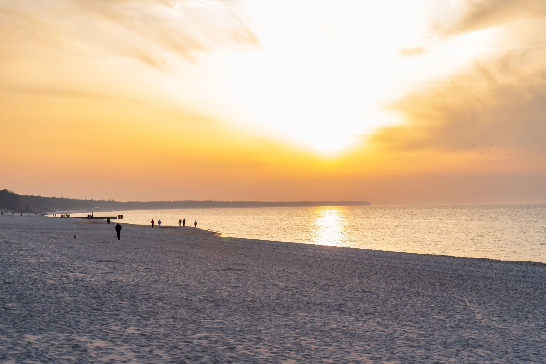 Experience the serene beauty of a sunset at Kołobrzeg Beach, showcasing vibrant colors and tranquil waves. — Trójmiasto