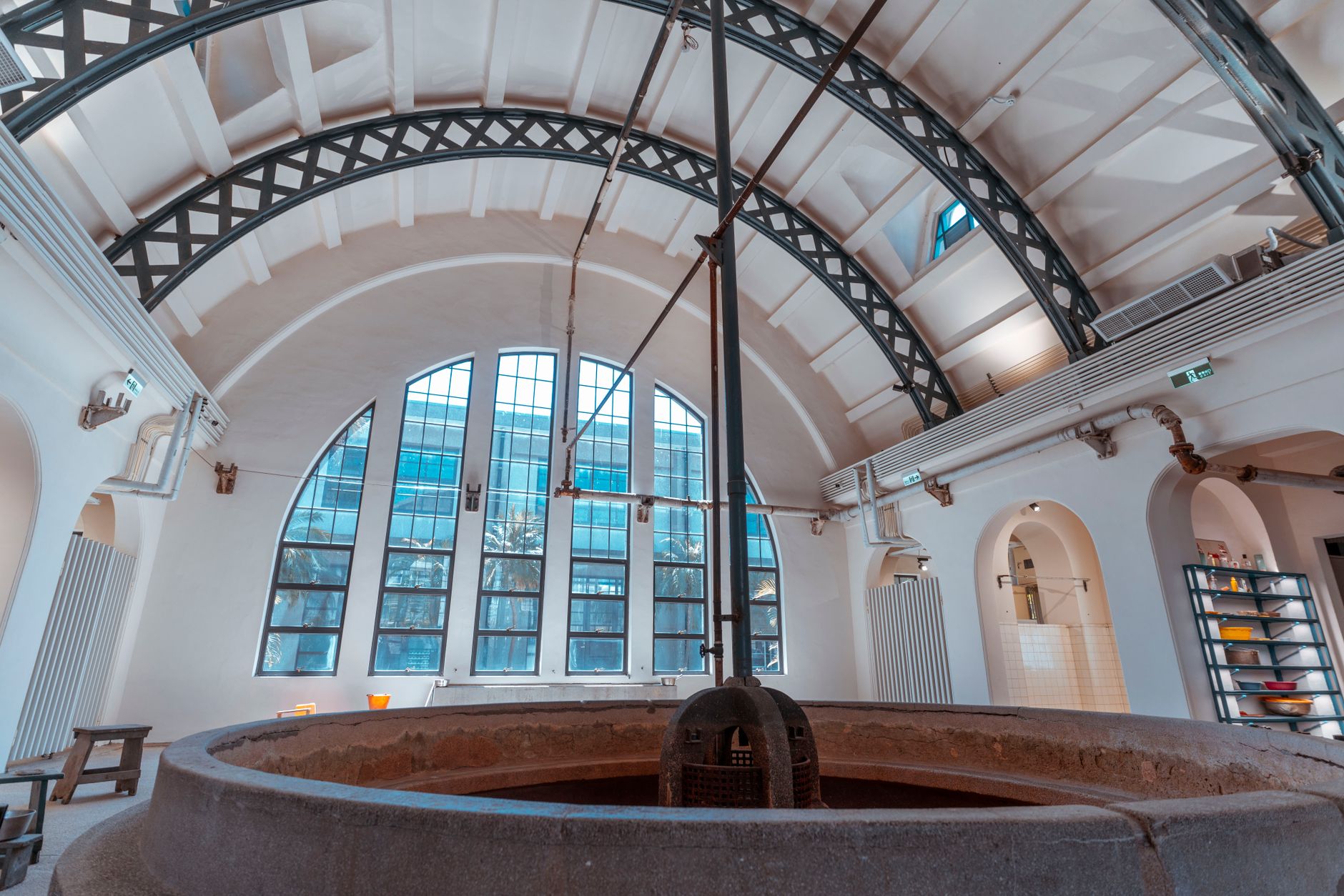 Interior of an industrial bathhouse featuring a large arched roof and architectural details. — Trójmiasto