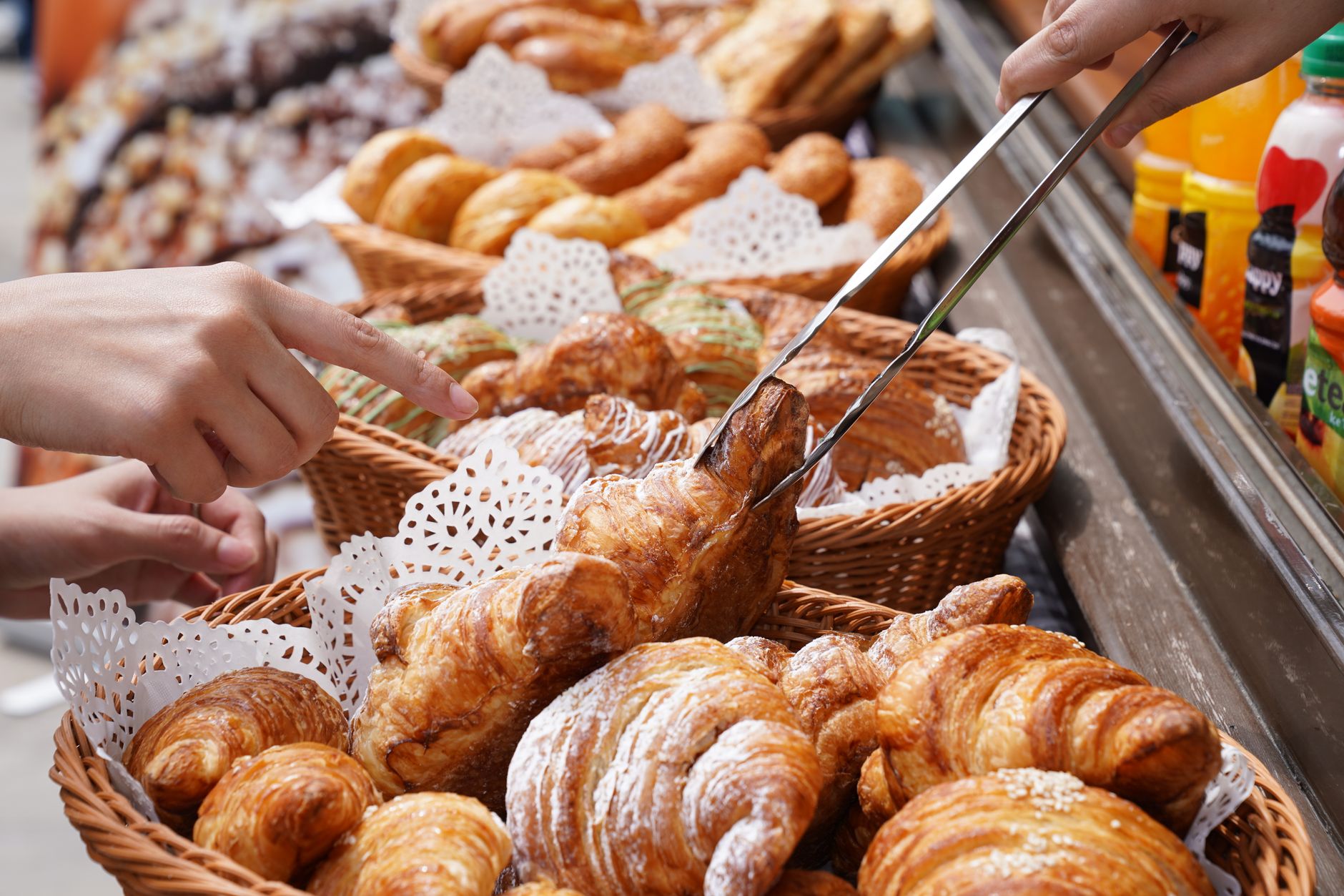 A hands-on selection of fresh croissants at an outdoor market, depicting vibrant food variety. — Trójmiasto