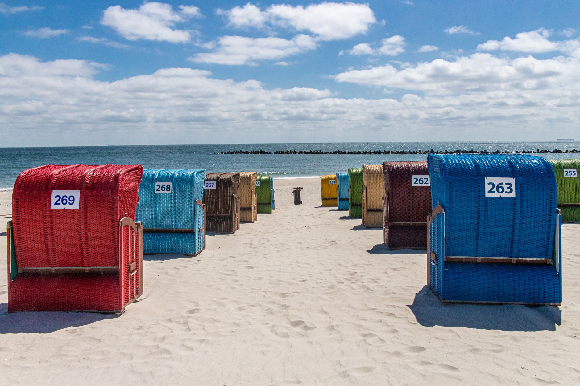 Vibrant beach basket chairs on sandy Helgoland beach overlooking the sea. — Trójmiasto