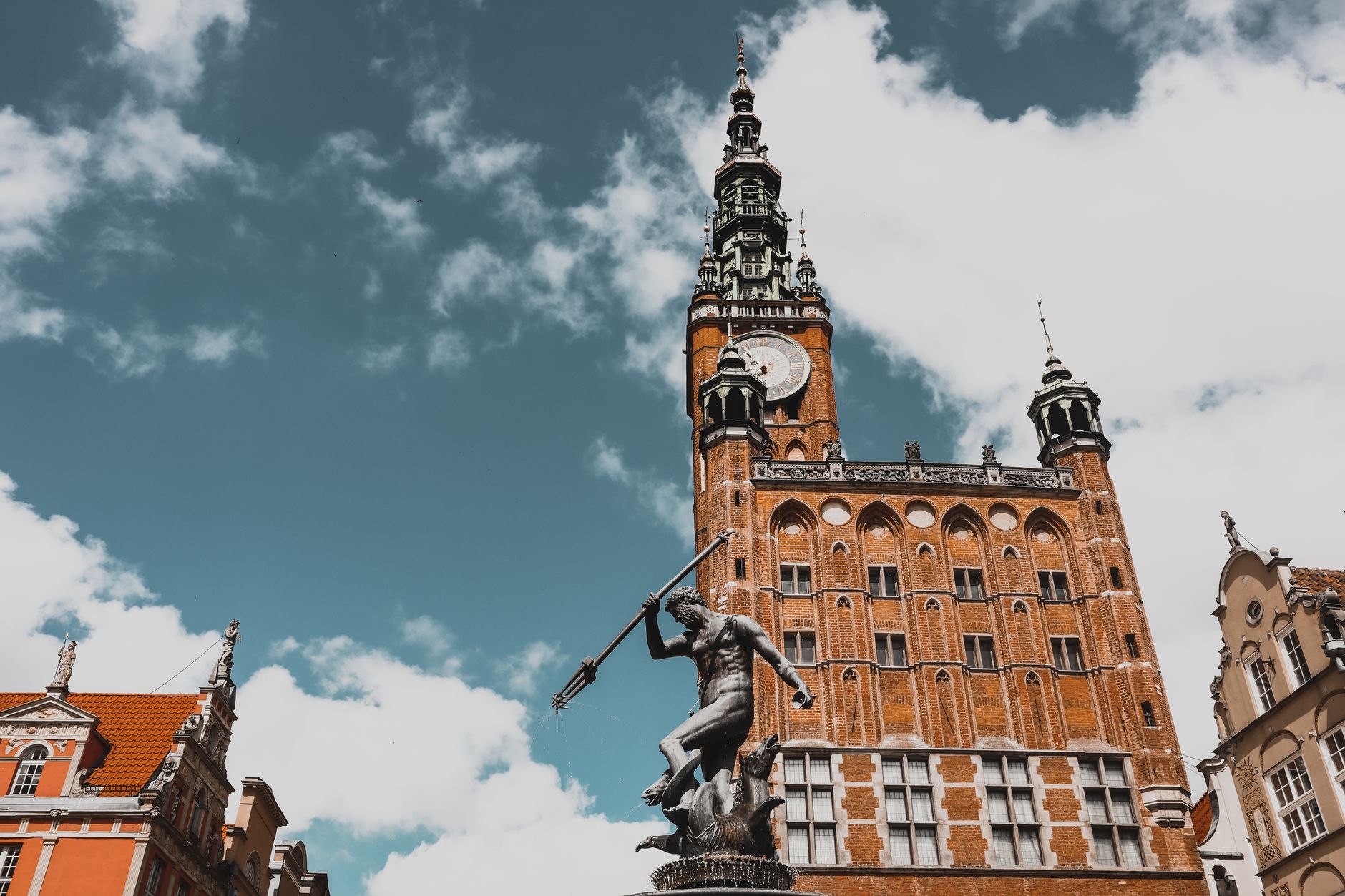Neptune's Fountain and historic Gdańsk Town Hall in a vibrant cityscape under a bright sky. — Trójmiasto