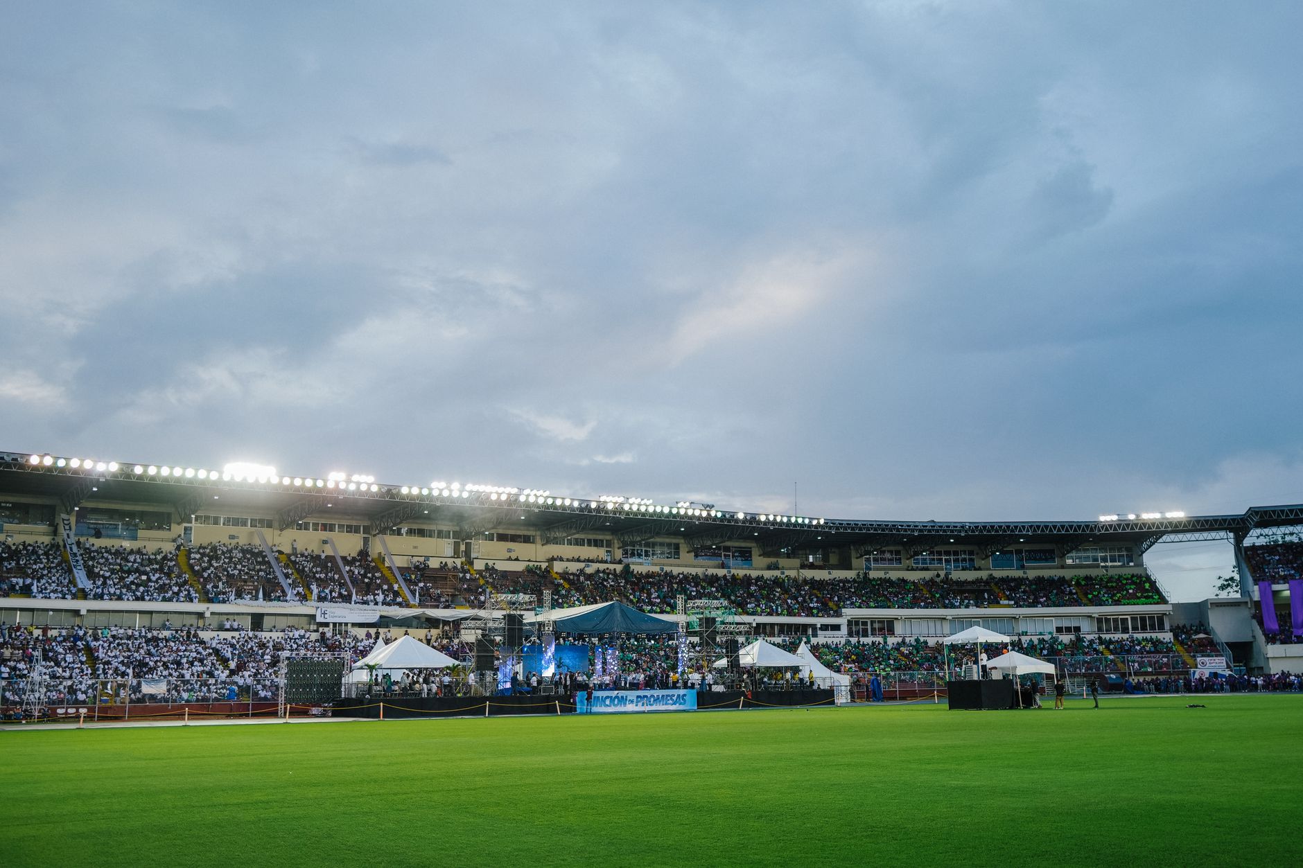 Large illuminated stadium filled with spectators on a cloudy day, ideal for sports or concert events. — Trójmiasto