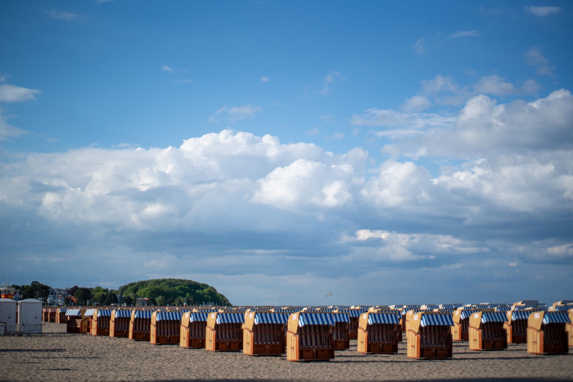 Strandkorb beach chairs under a blue sky in Lübeck, Germany, showcasing a tranquil coastal scene. — Trójmiasto