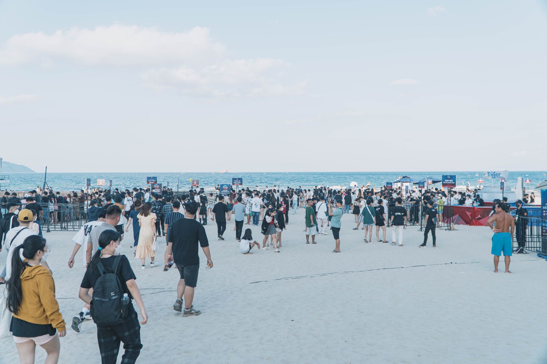 A large group of people enjoying a day at the beach with clear blue skies. — Trójmiasto
