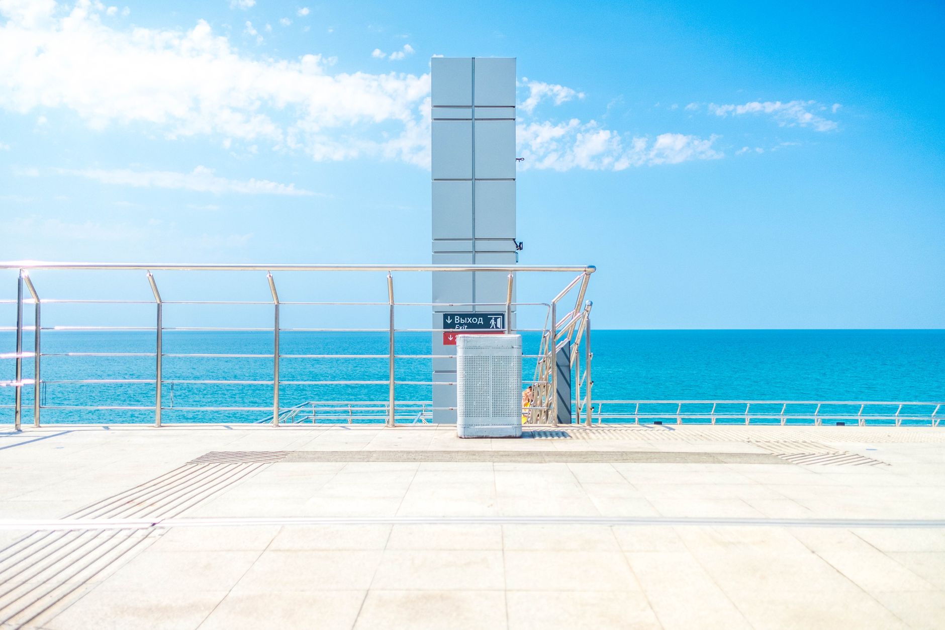 Summer view of Sochi's seaside promenade showcasing blue skies and a calm ocean. — Trójmiasto