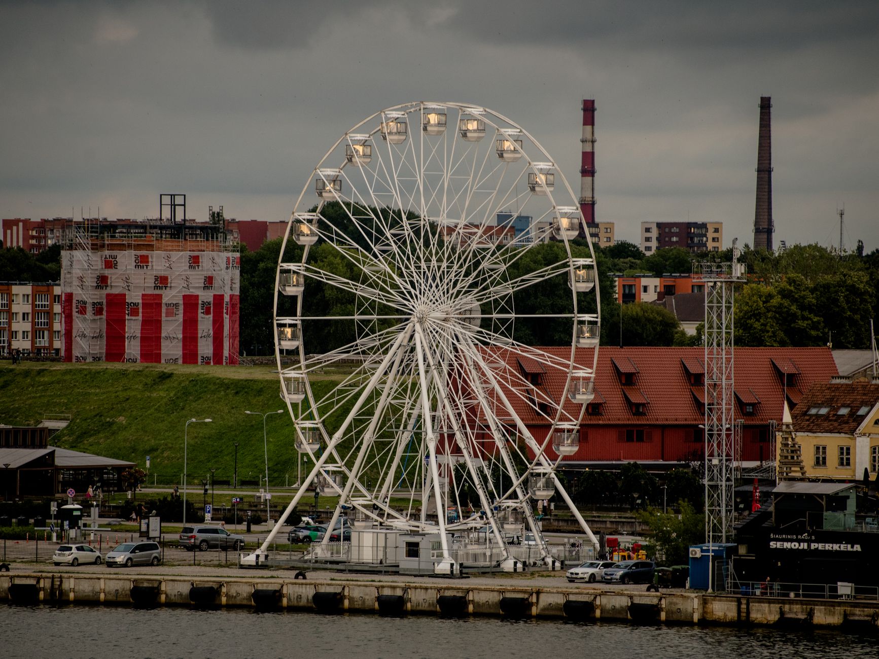 Explore the Klaipėda cityscape with a prominent Ferris wheel on the waterfront, Lithuania. — Trójmiasto
