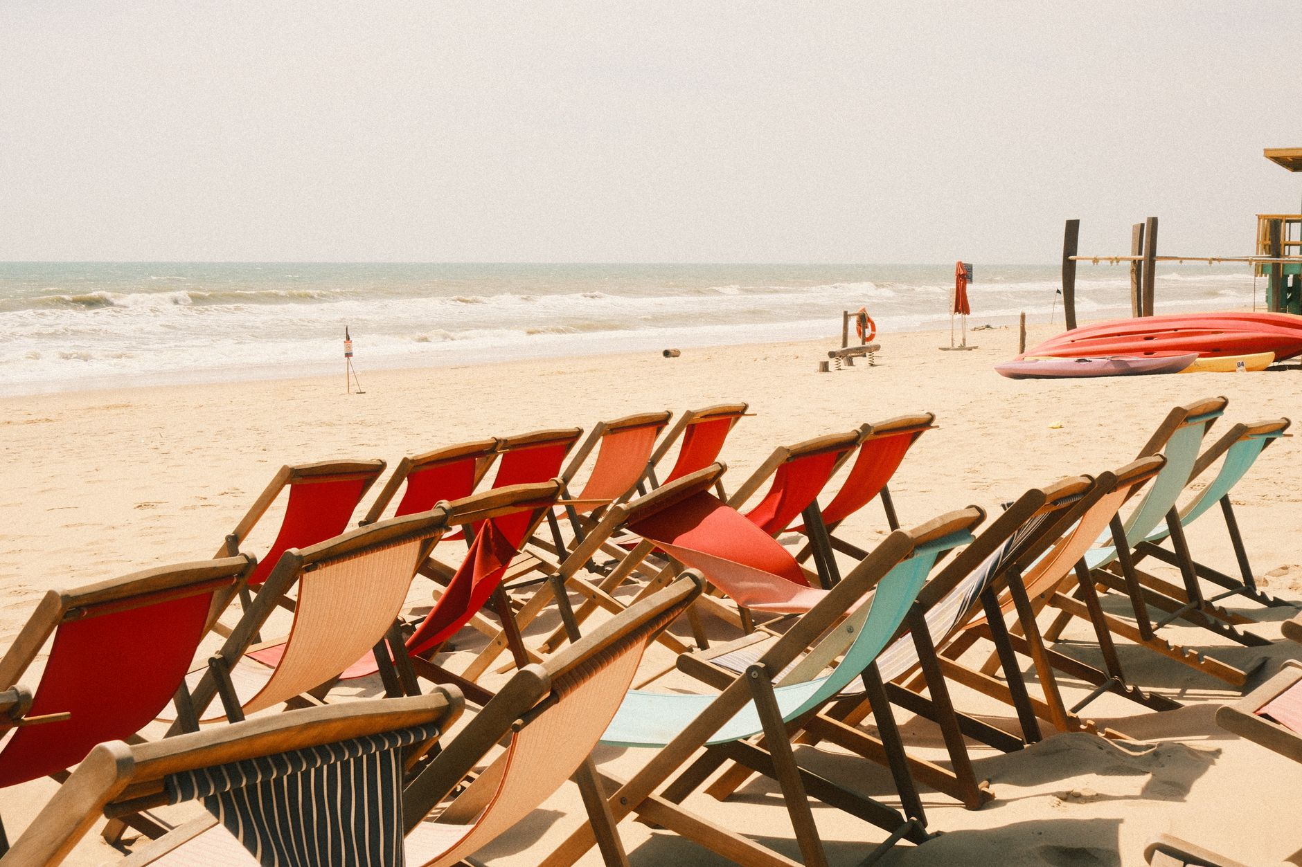 Rows of colorful beach chairs on a sandy shore in Phan Thiet, Vietnam, under bright sun. — Trójmiasto