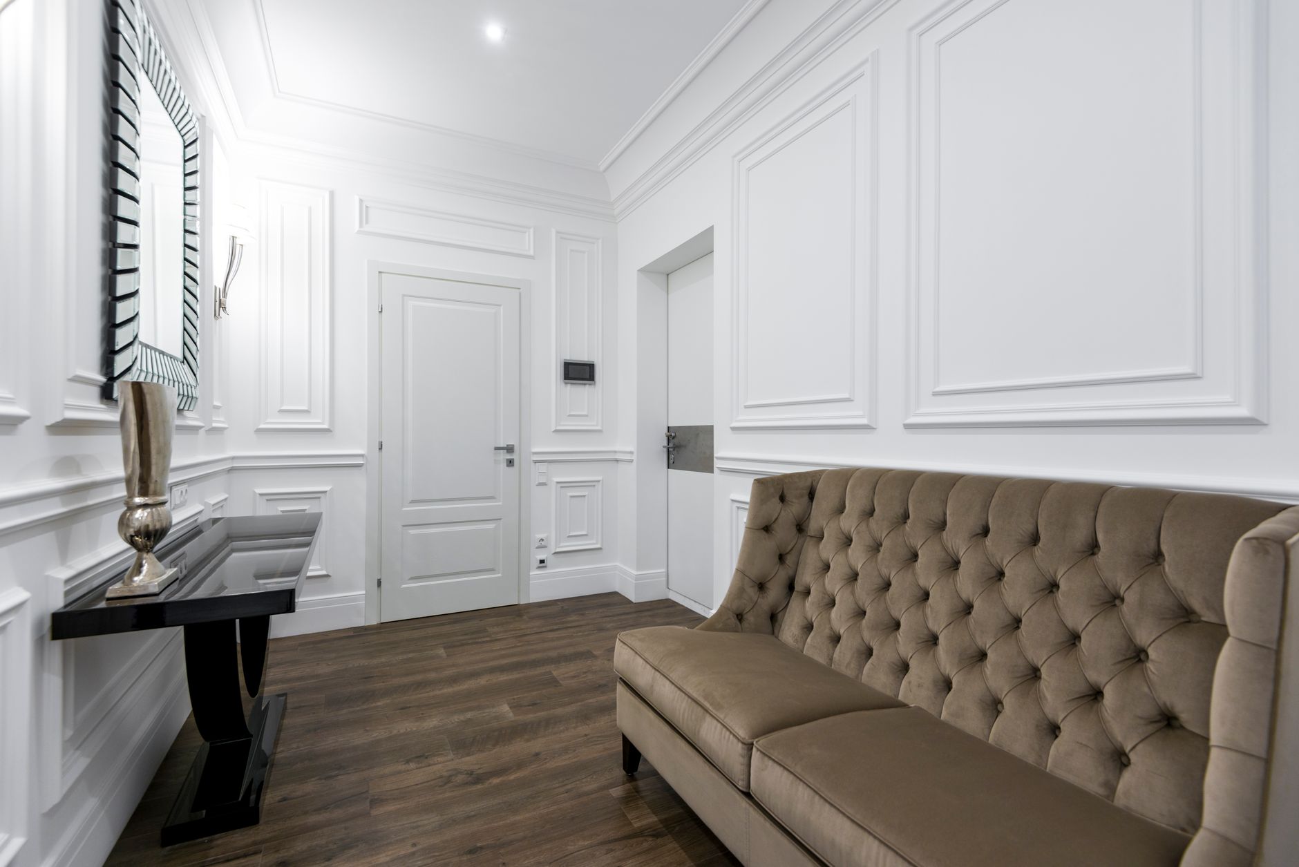 A sophisticated interior with a tufted sofa and a decorative mirror, highlighting classic design elements. — Trójmiasto