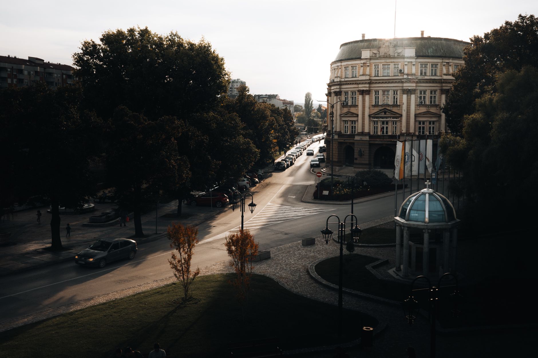 A city street view with historic architecture and soft sunset lighting creating dramatic shadows. — Trójmiasto