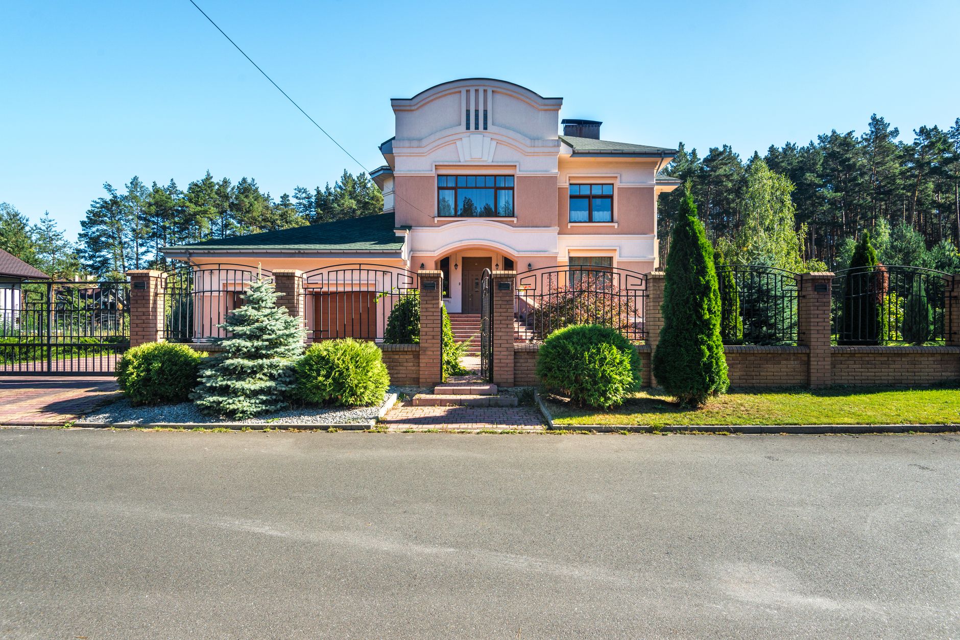 Beautiful luxury suburban house with landscaped garden and gated entrance on a sunny day. — Trójmiasto