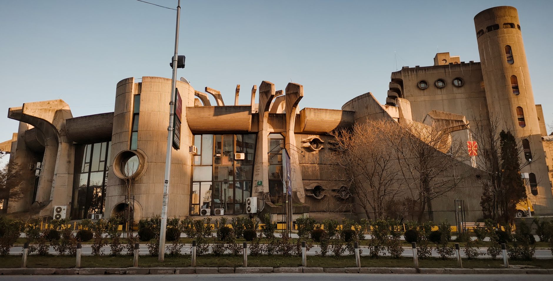 Intriguing Brutalist architecture of the Skopje Post Office captured in golden hour. — Trójmiasto