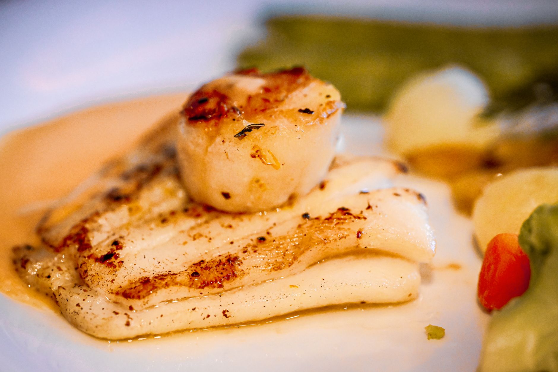 Delicious pan-seared scallops and grilled fish served with vegetables, ideal for culinary enthusiasts. — Trójmiasto