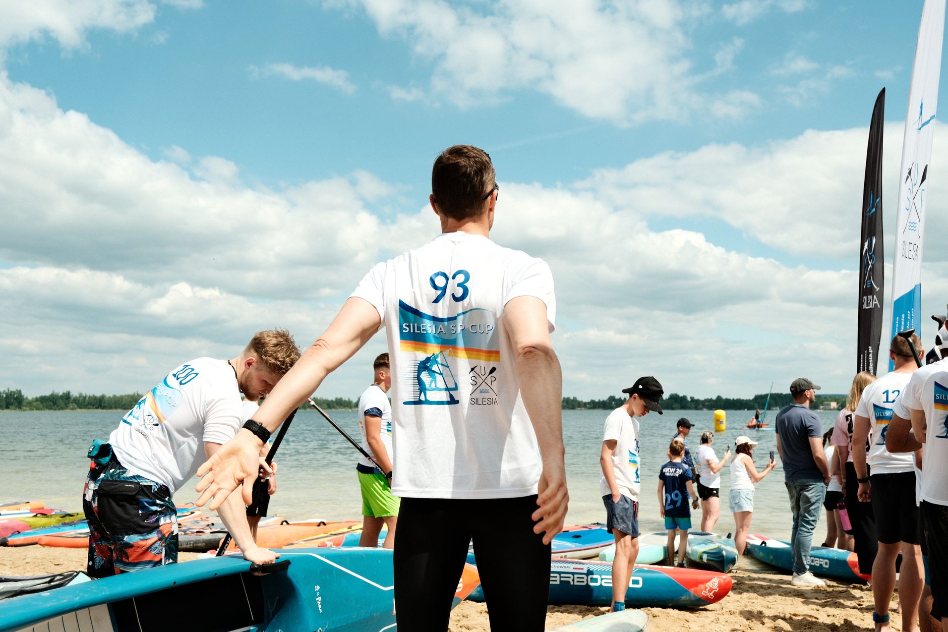 Group of people participating in a SUP Cup event at the beach. — Trójmiasto