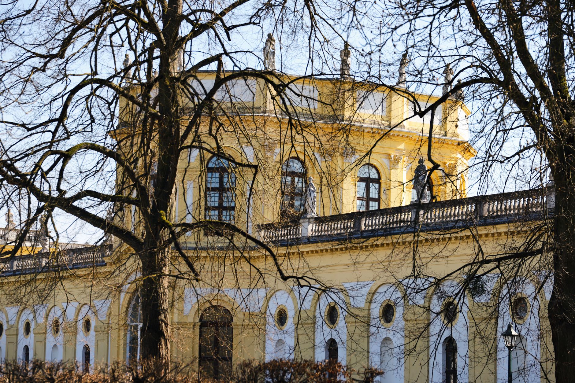 Beautiful view of the Orangerie in Kassel, Hessen, with tree branches framing the historic architecture in spring sunlight. — Trójmiasto
