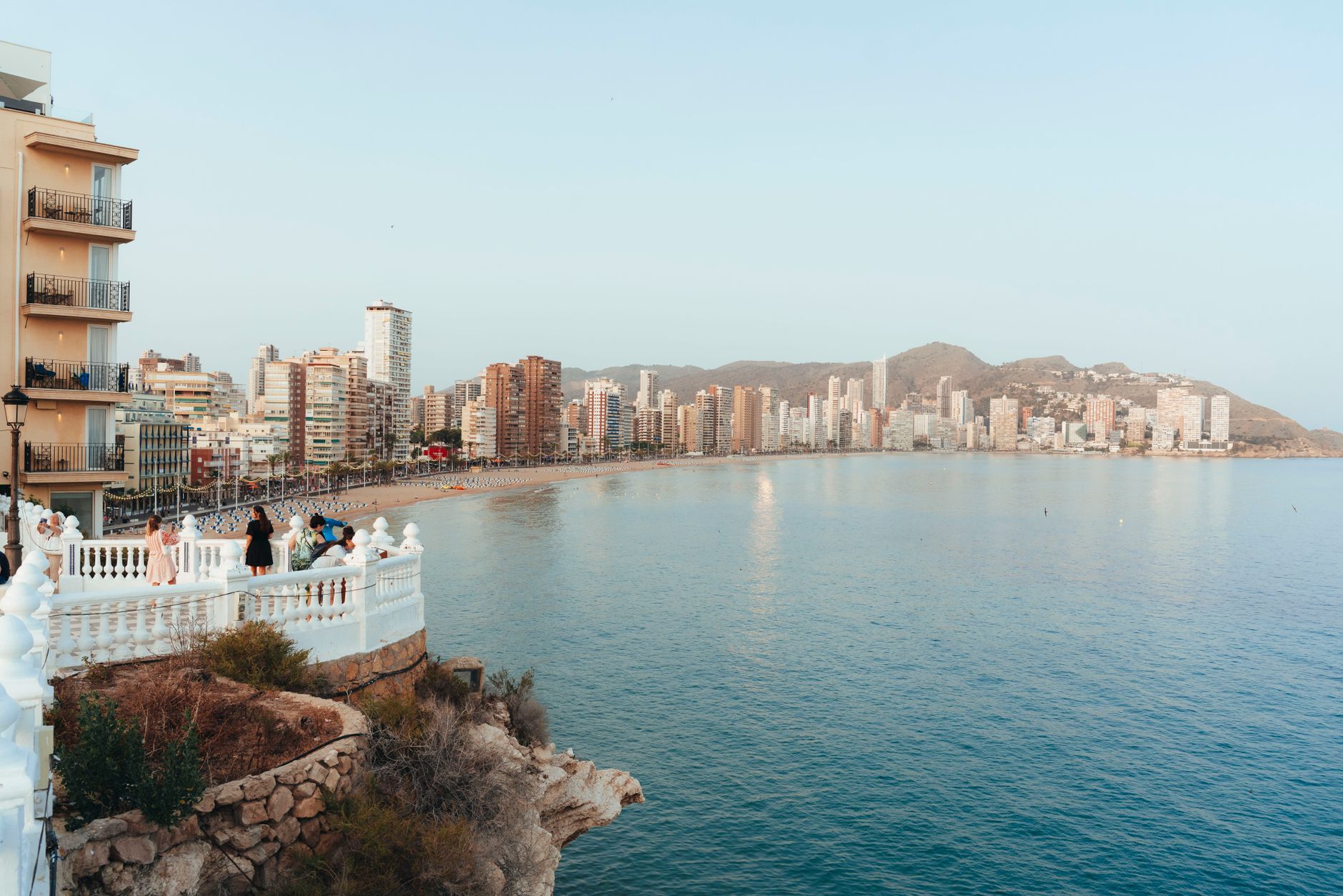 Scenic seaside view of Benidorm's skyline with people enjoying the lookout at dusk. — Trójmiasto