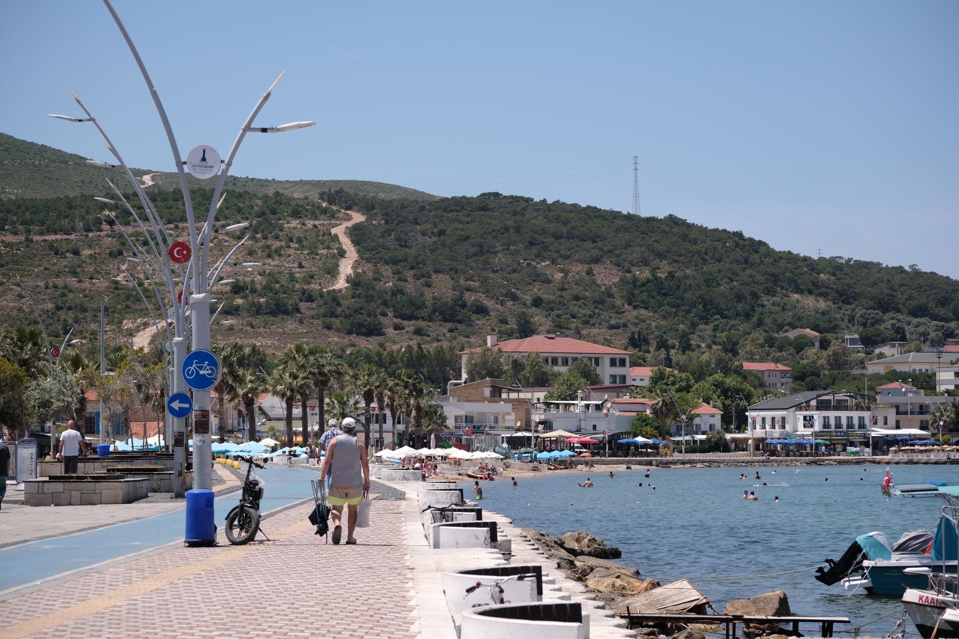 A vibrant coastal scene in Foça, İzmir, Türkiye with people enjoying a summer day by the sea. — Trójmiasto