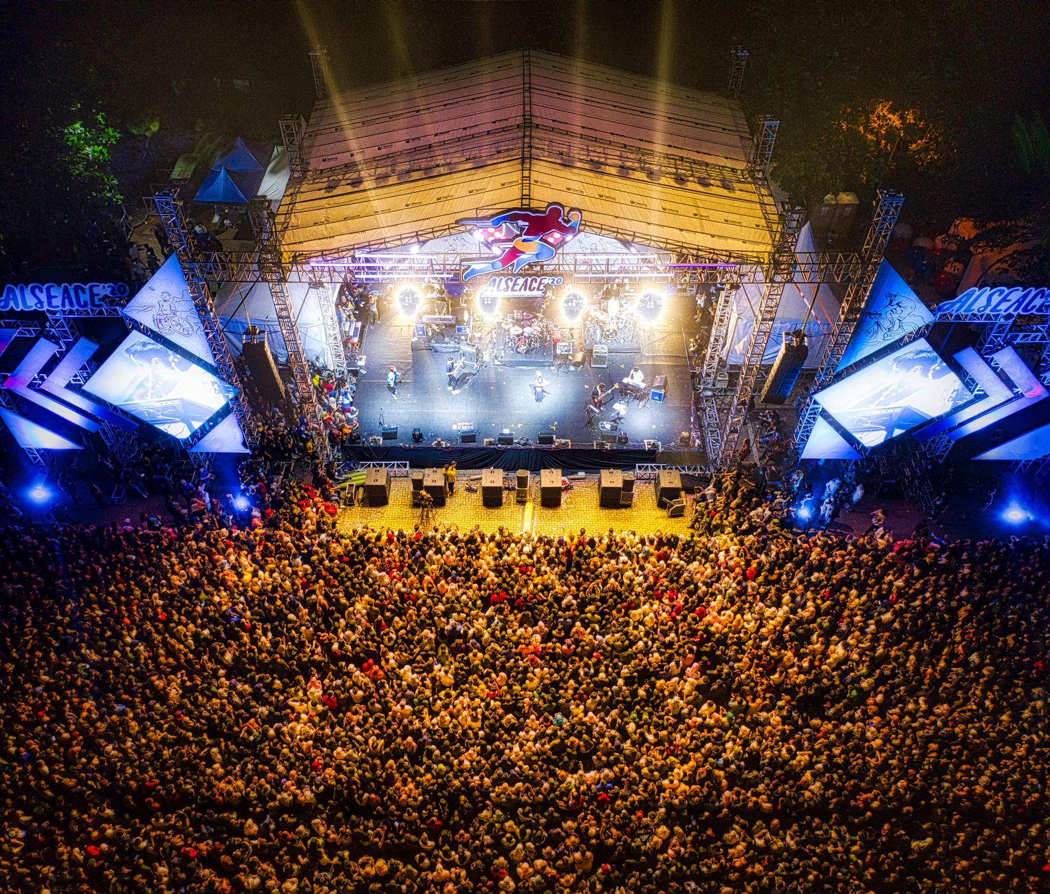 A lively aerial shot showcasing a large concert crowd at a bustling music festival. — Trójmiasto