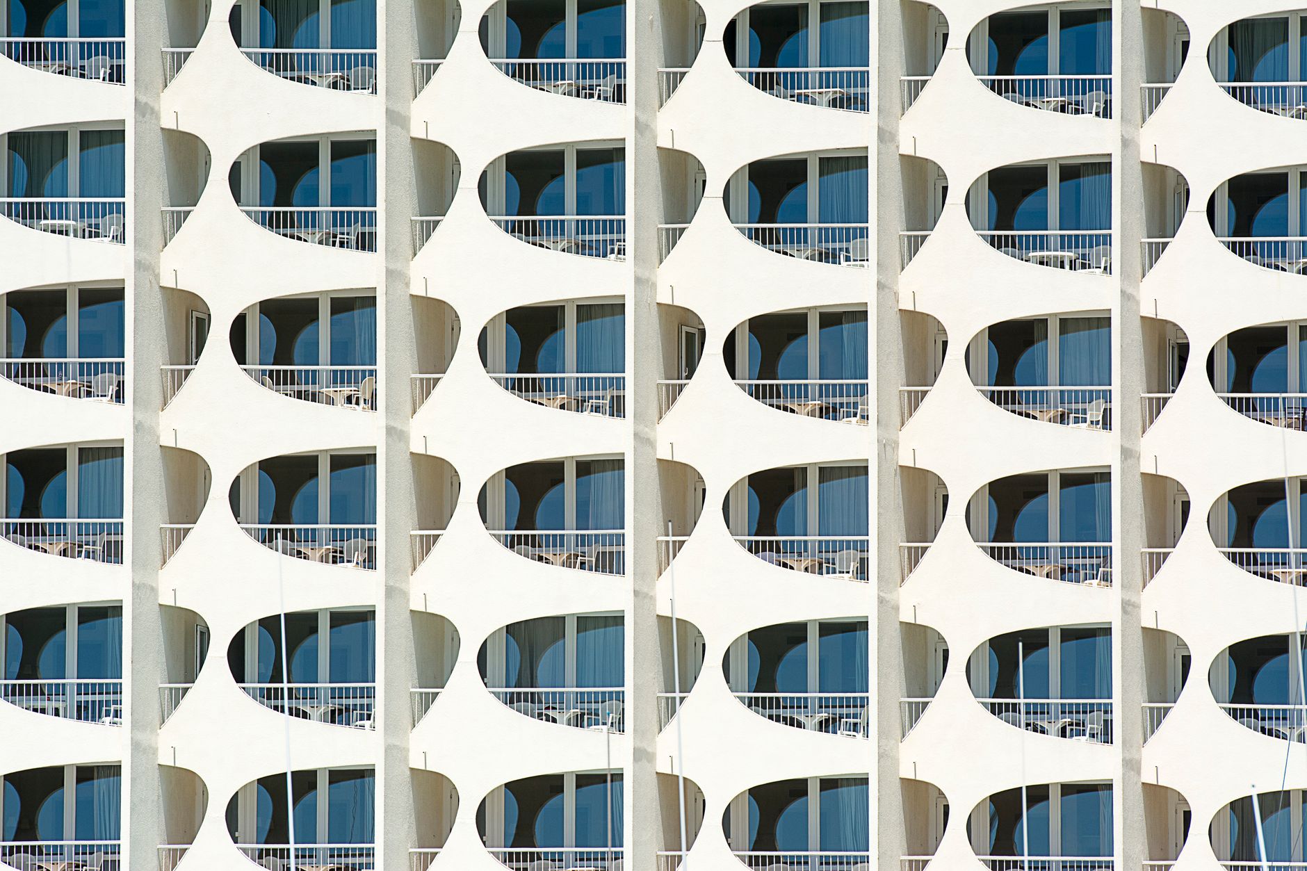 Detailed view of a modern building facade with geometric patterns and blue windows. — Trójmiasto