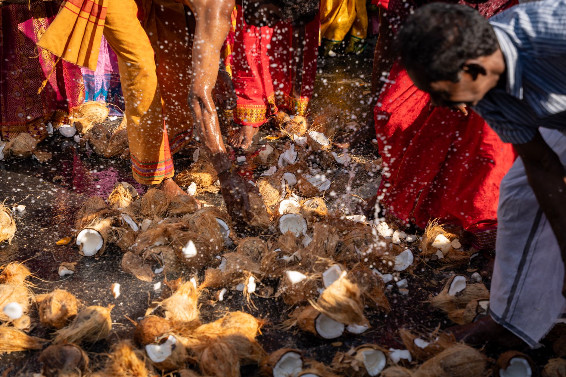 Colorful scene of people participating in coconut-breaking ritual at a Hindu festival. — Trójmiasto