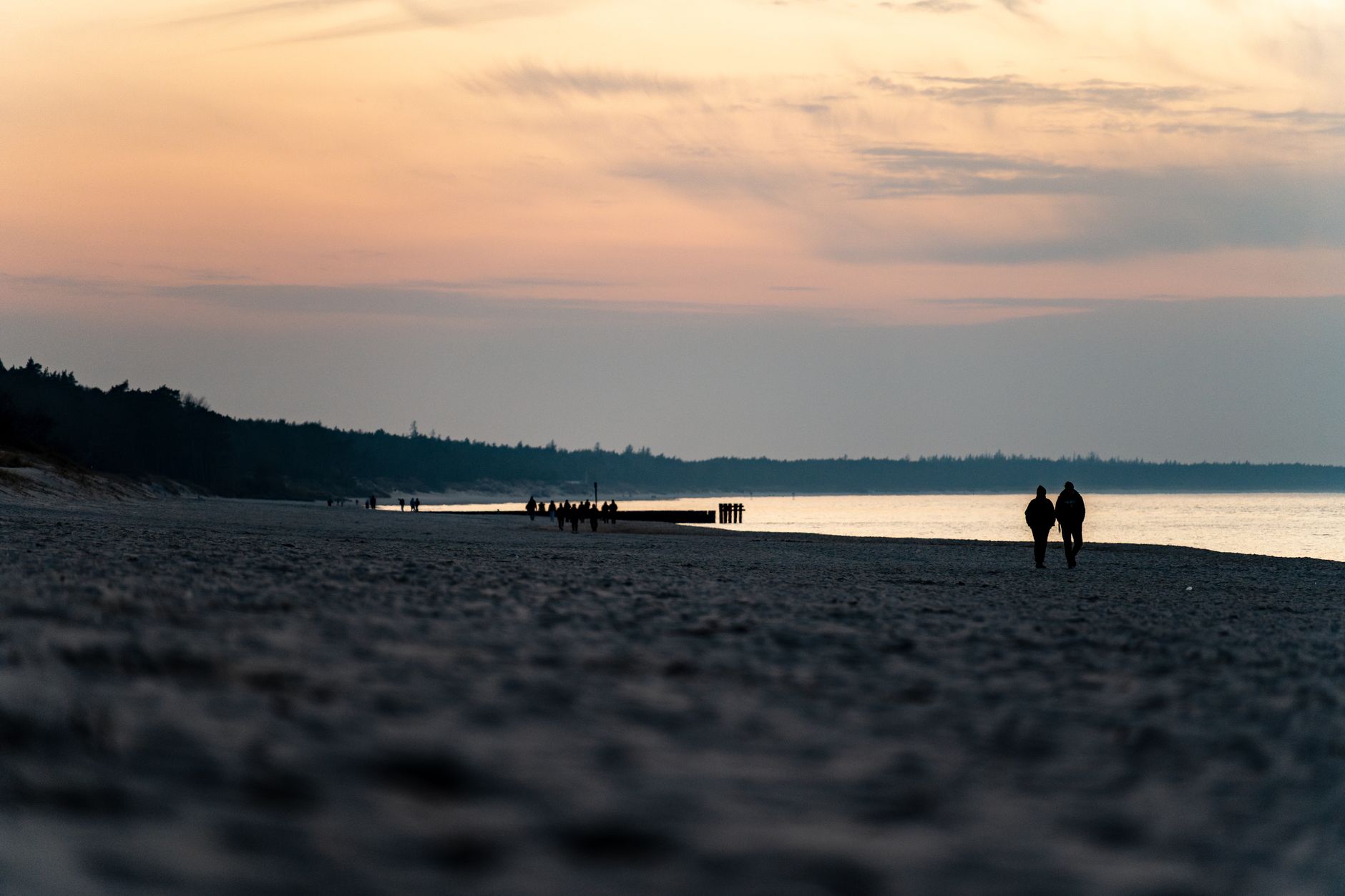 A serene sunset view of a couple walking on Kołobrzeg beach, Poland. — Trójmiasto