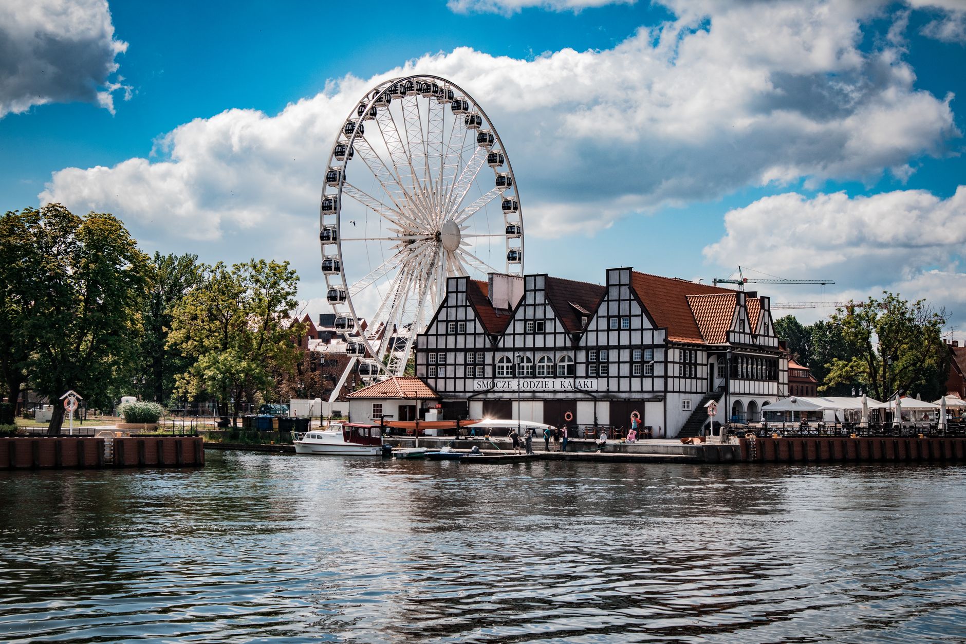 Explore the picturesque waterfront of Gdańsk with its iconic Ferris wheel and charming architecture. — Trójmiasto