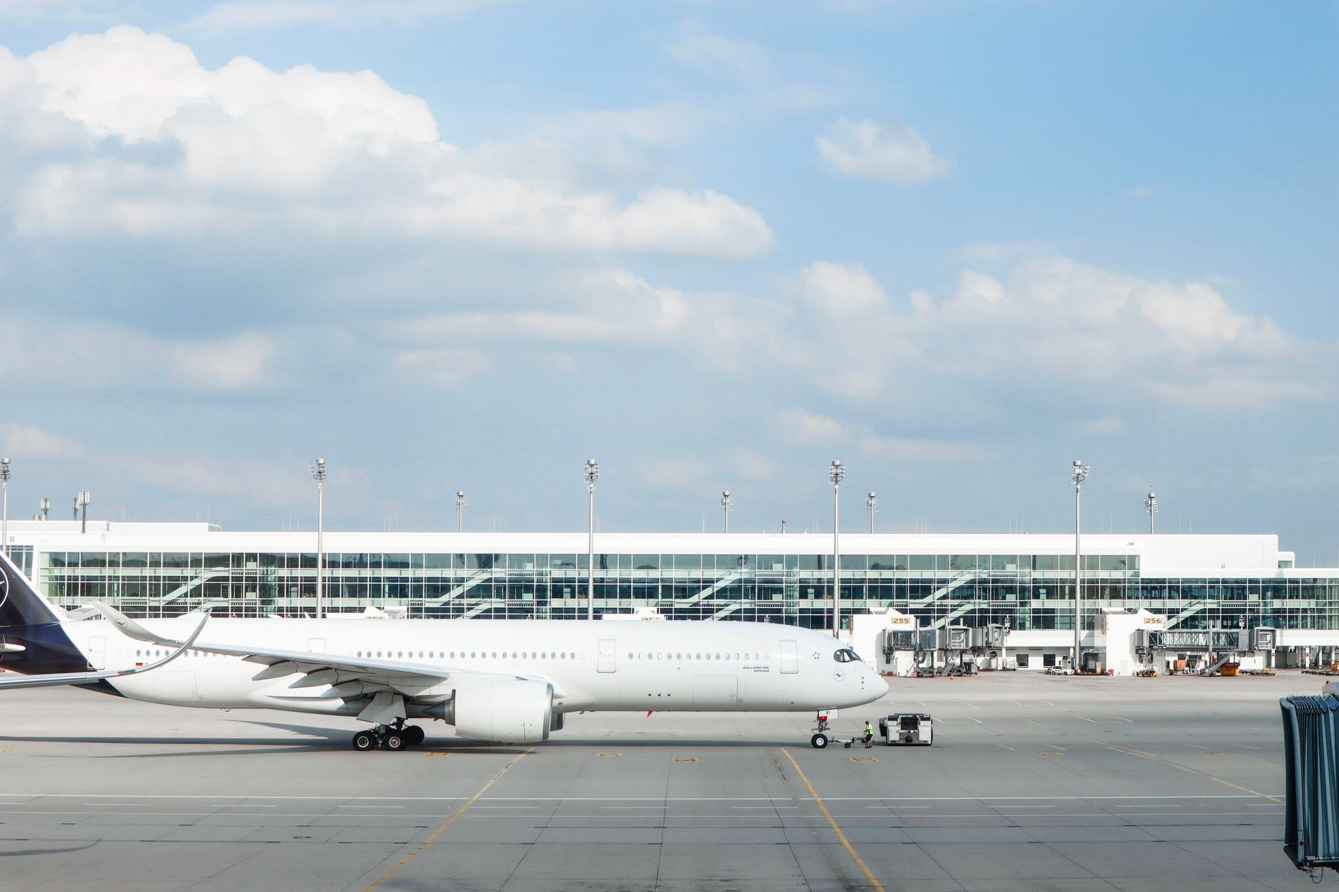 Widebody aircraft parked at an airport gate during clear day with terminal building visible. — Trójmiasto