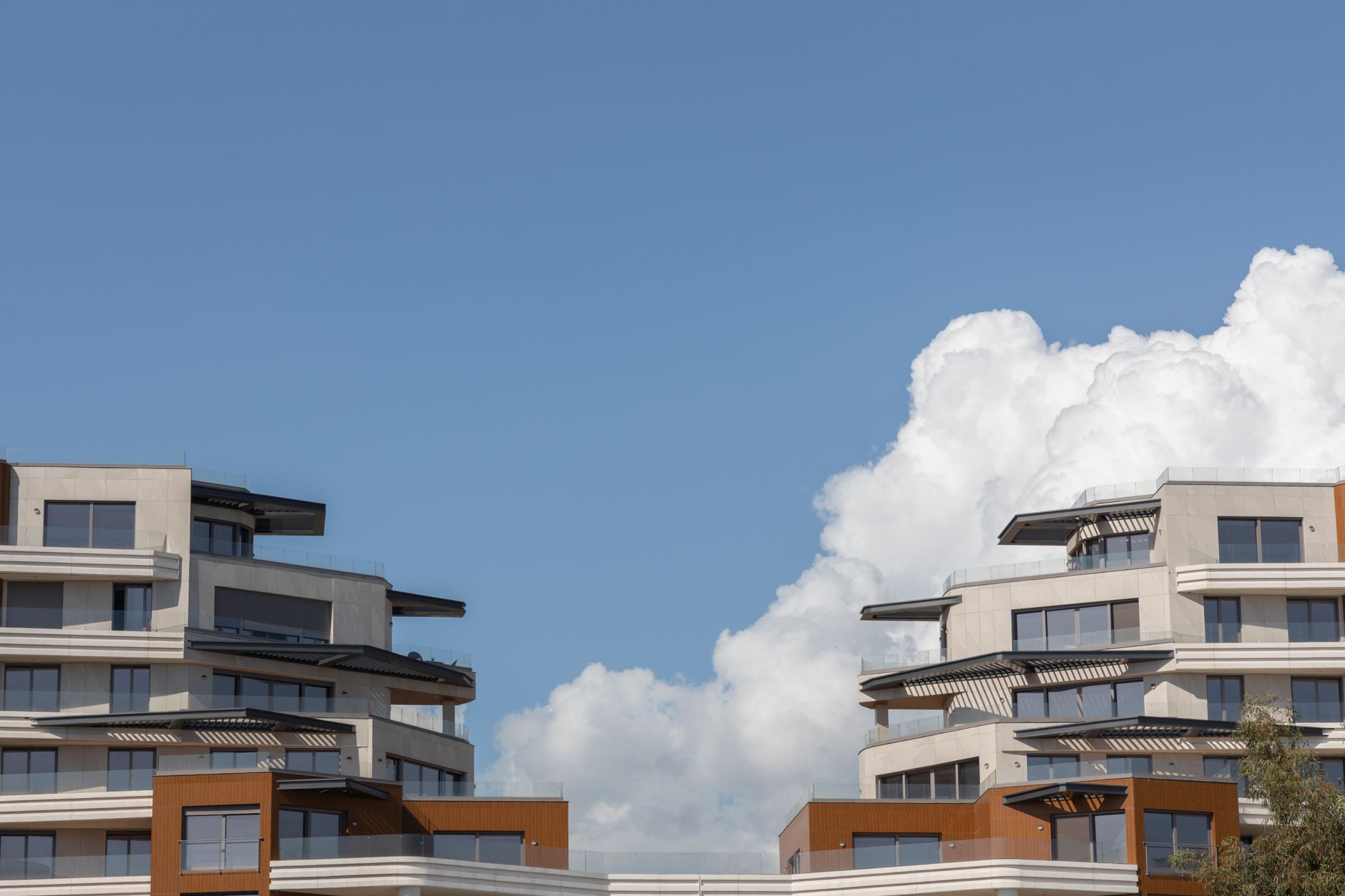 Contemporary urban architecture under a bright blue sky with clouds. — Trójmiasto