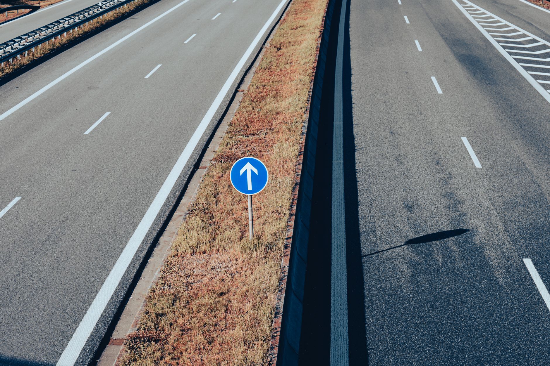 Aerial view of an empty highway highlighting a traffic sign with an arrow, emphasizing direction and transportation infrastructure. — Trójmiasto