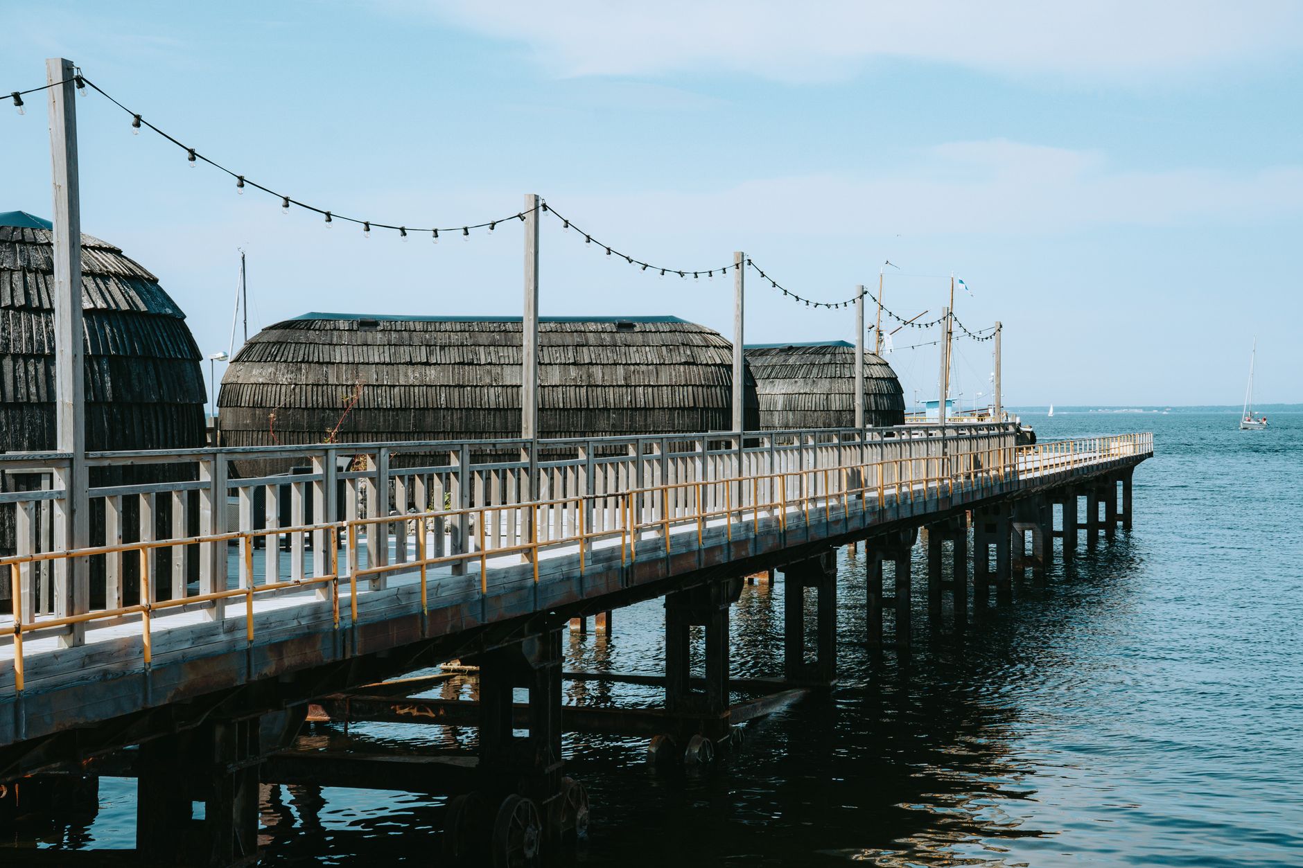 Explore the serene waterfront and traditional structures in Tallinn, Estonia, on a bright summer day. — Trójmiasto