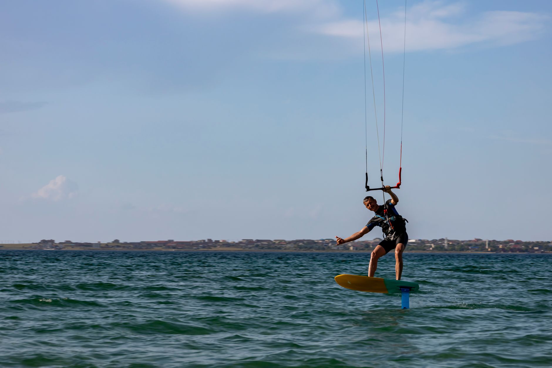 Dynamic image of a kiteboarder skimming across open sea waters, showcasing adrenaline and skill. — Trójmiasto