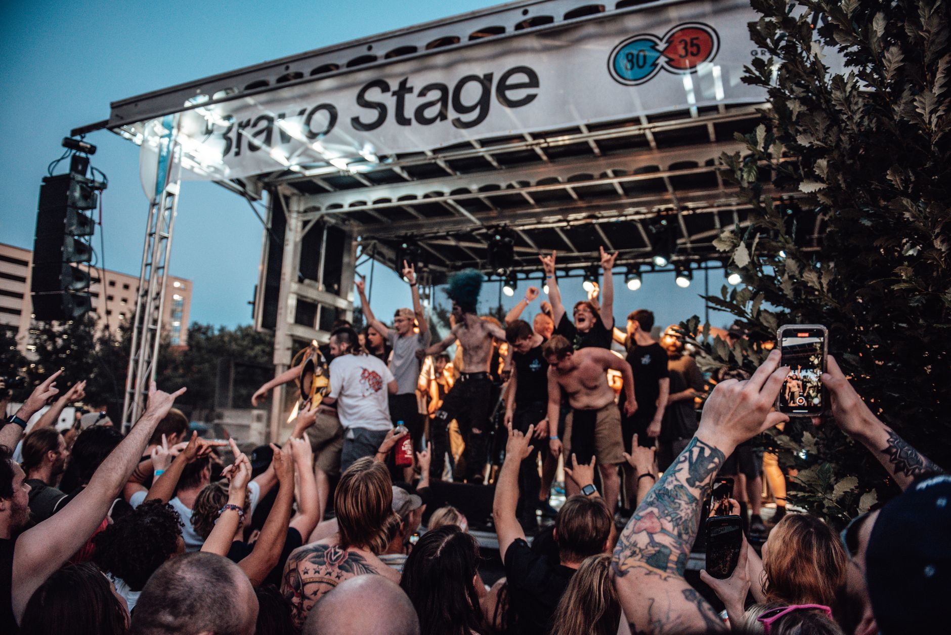 A lively outdoor concert scene with a diverse crowd enjoying the music under bright stage lights. — Trójmiasto
