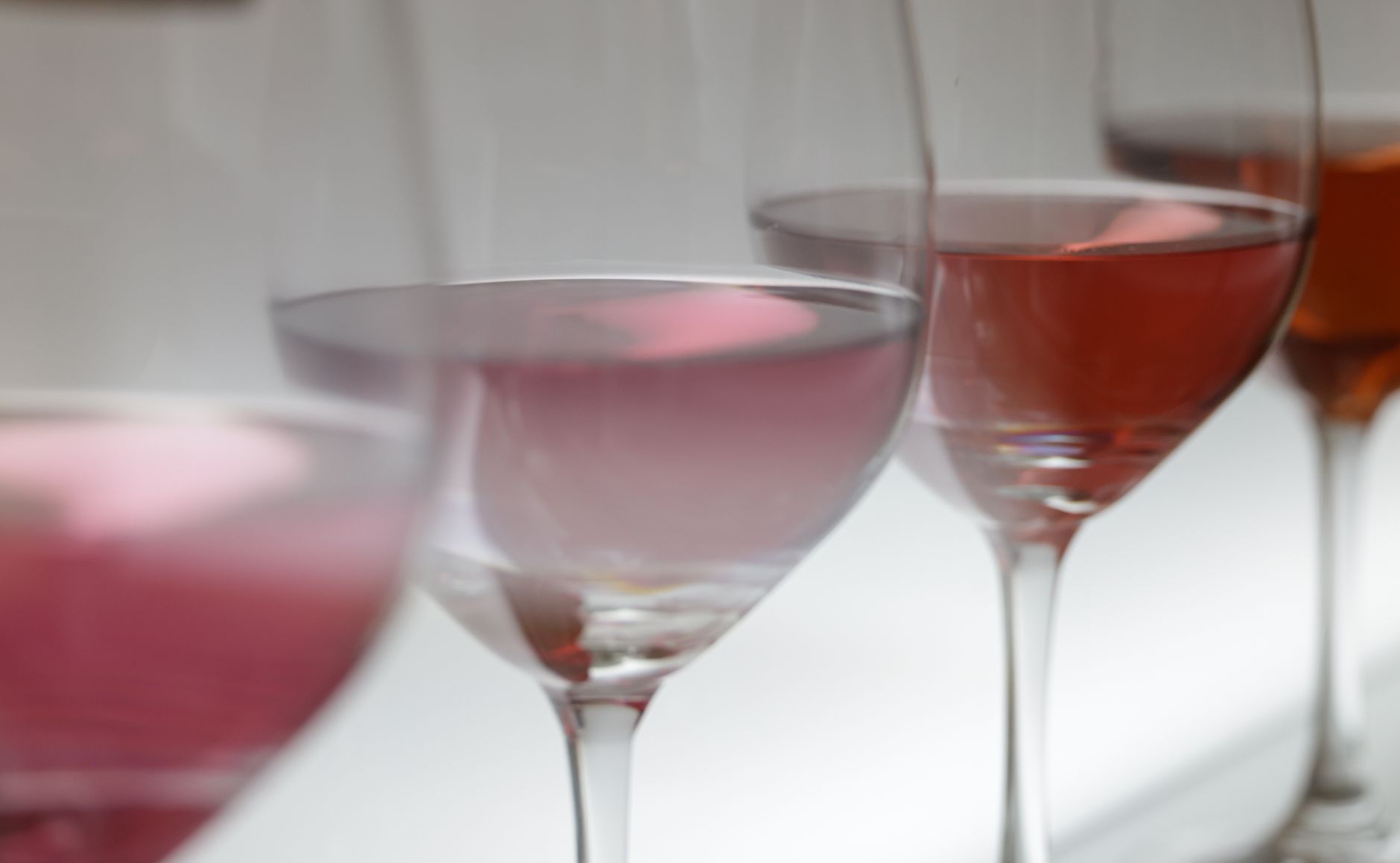 Close-up of various wine glasses filled with rosé in soft lighting, perfect for wine tasting events. — Trójmiasto