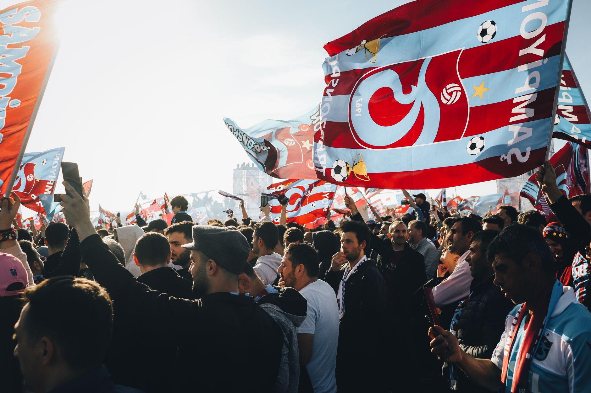 Energetic gathering with colorful flags at a lively outdoor event on a sunny day. — Trójmiasto