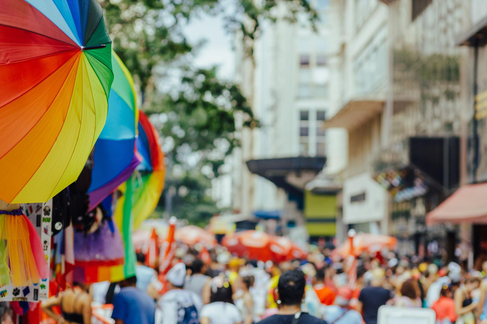 Colorful rainbow umbrellas adorn a lively outdoor city festival with a bustling crowd. — Trójmiasto
