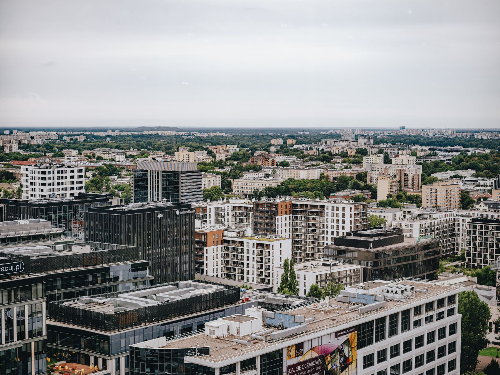 Aerial view of Warsaw skyline featuring modern and residential buildings under cloudy sky. — Trójmiasto