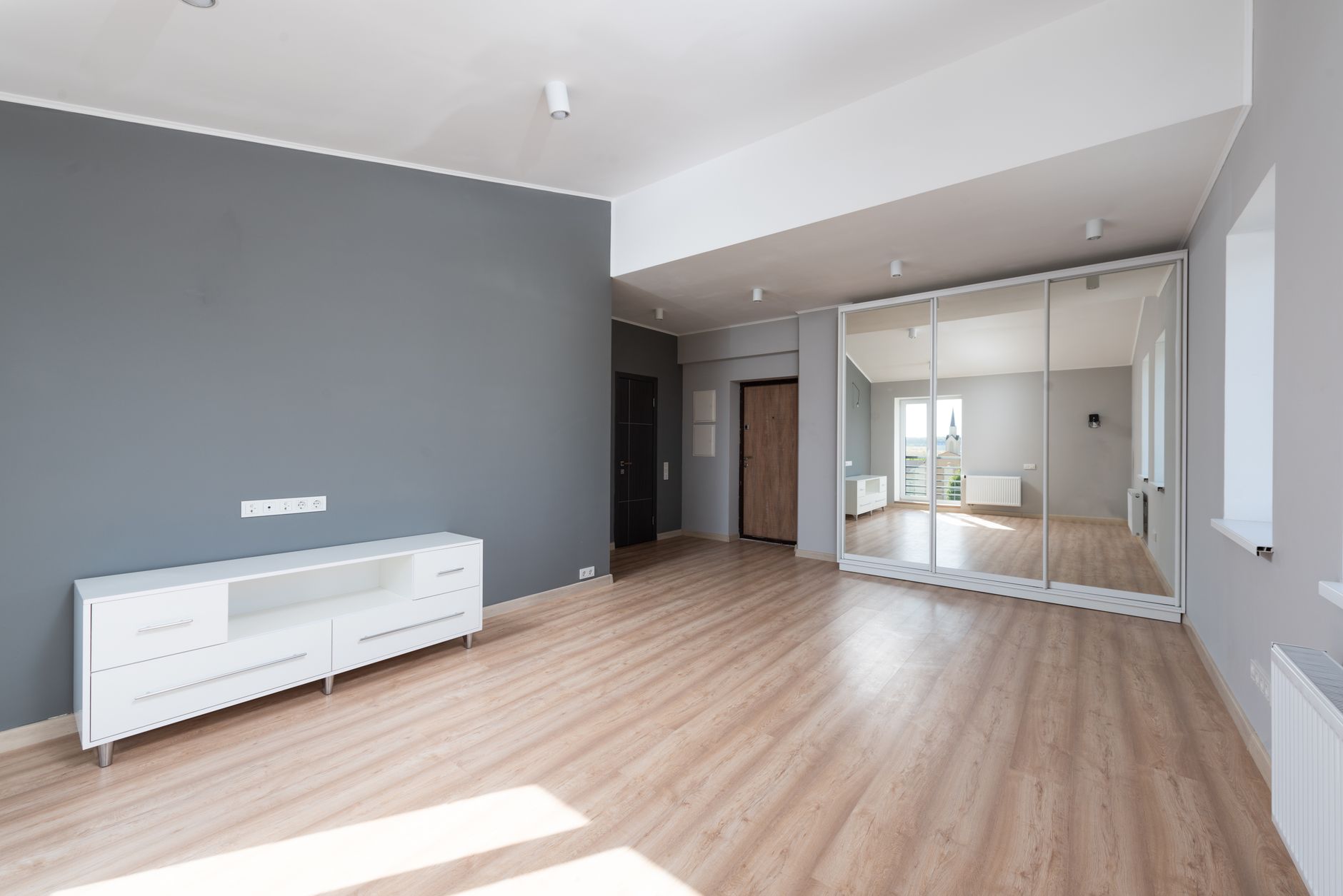 Spacious empty room with wooden flooring and minimalist style furniture. — Trójmiasto
