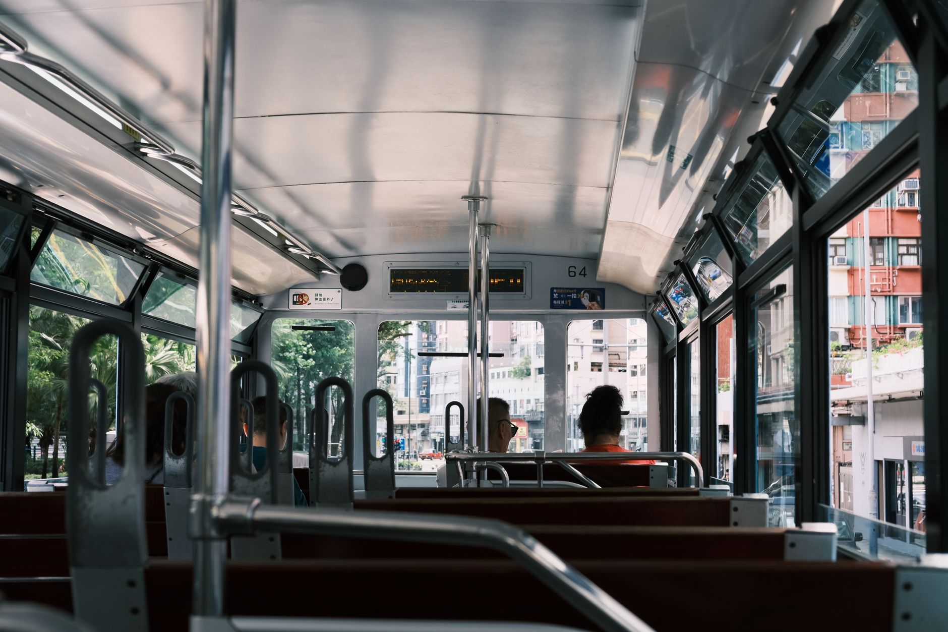 Interior view of a city tram showing passengers and urban scenery outside, highlighting daily commuting. — Trójmiasto
