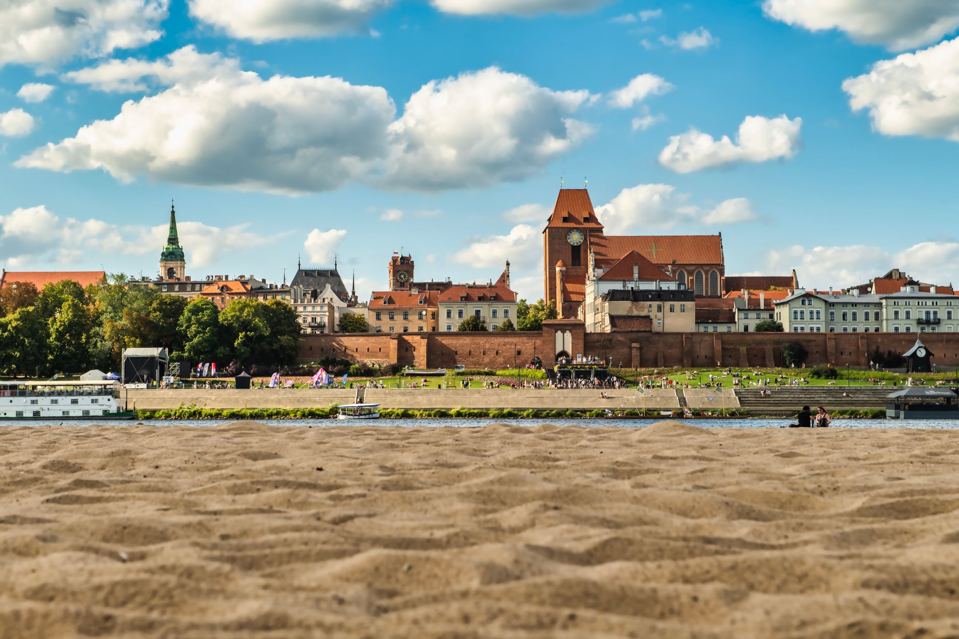 A picturesque view of Toruń's cityscape with architectural landmarks under a vibrant blue sky. — Trójmiasto