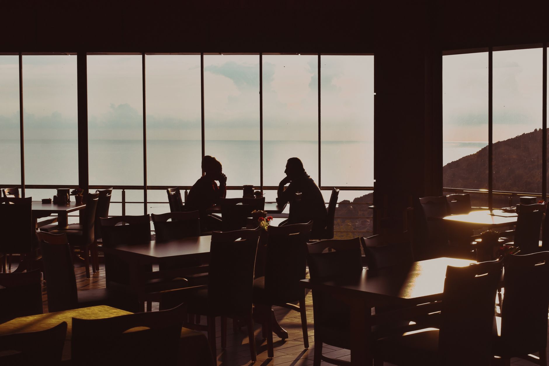 A serene sunset view from a seaside restaurant in Cide, Turkey, capturing silhouettes enjoying the evening. — Trójmiasto