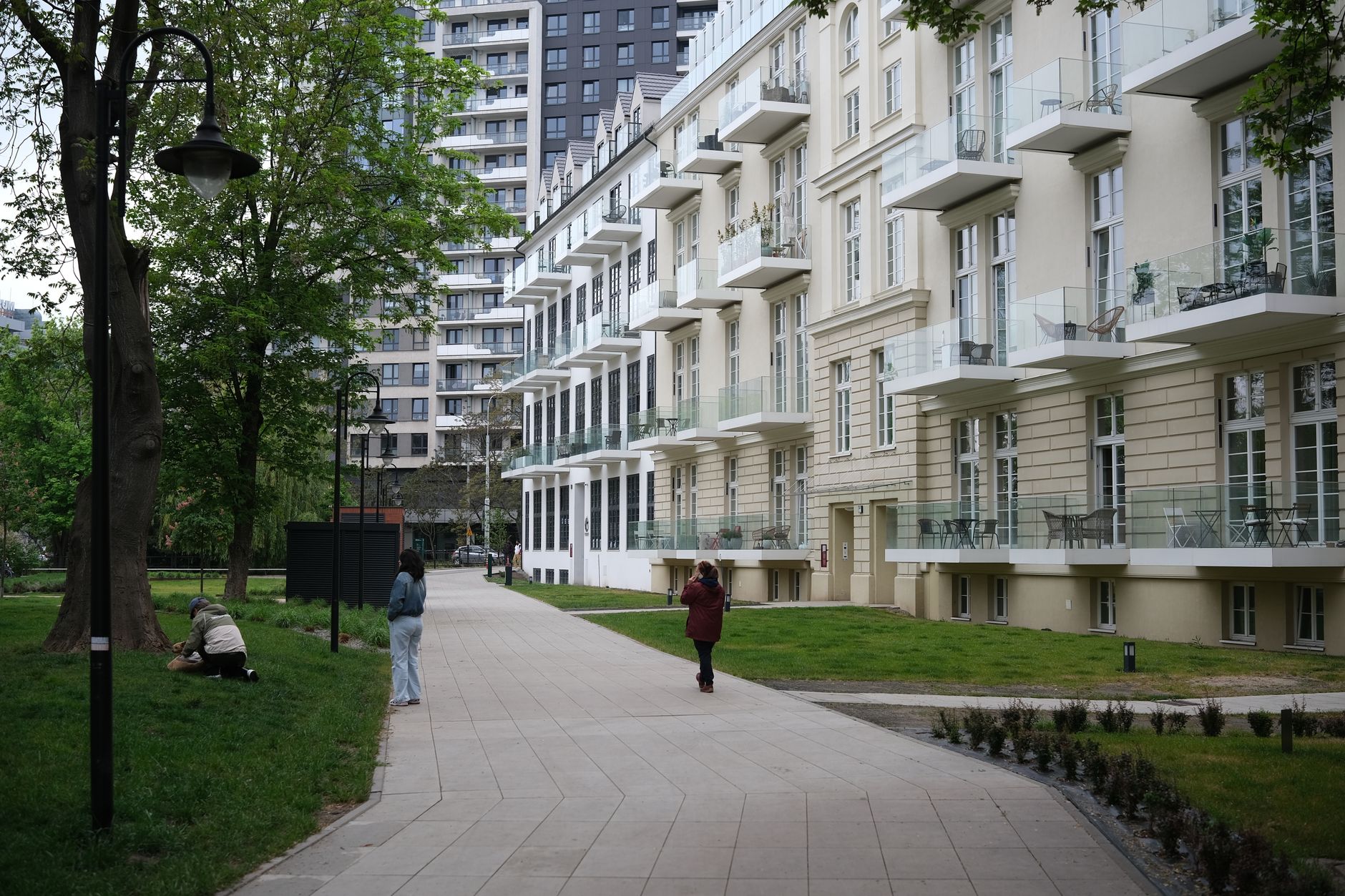 Contemporary apartment buildings next to a lush city park with people enjoying the outdoor space. — Trójmiasto