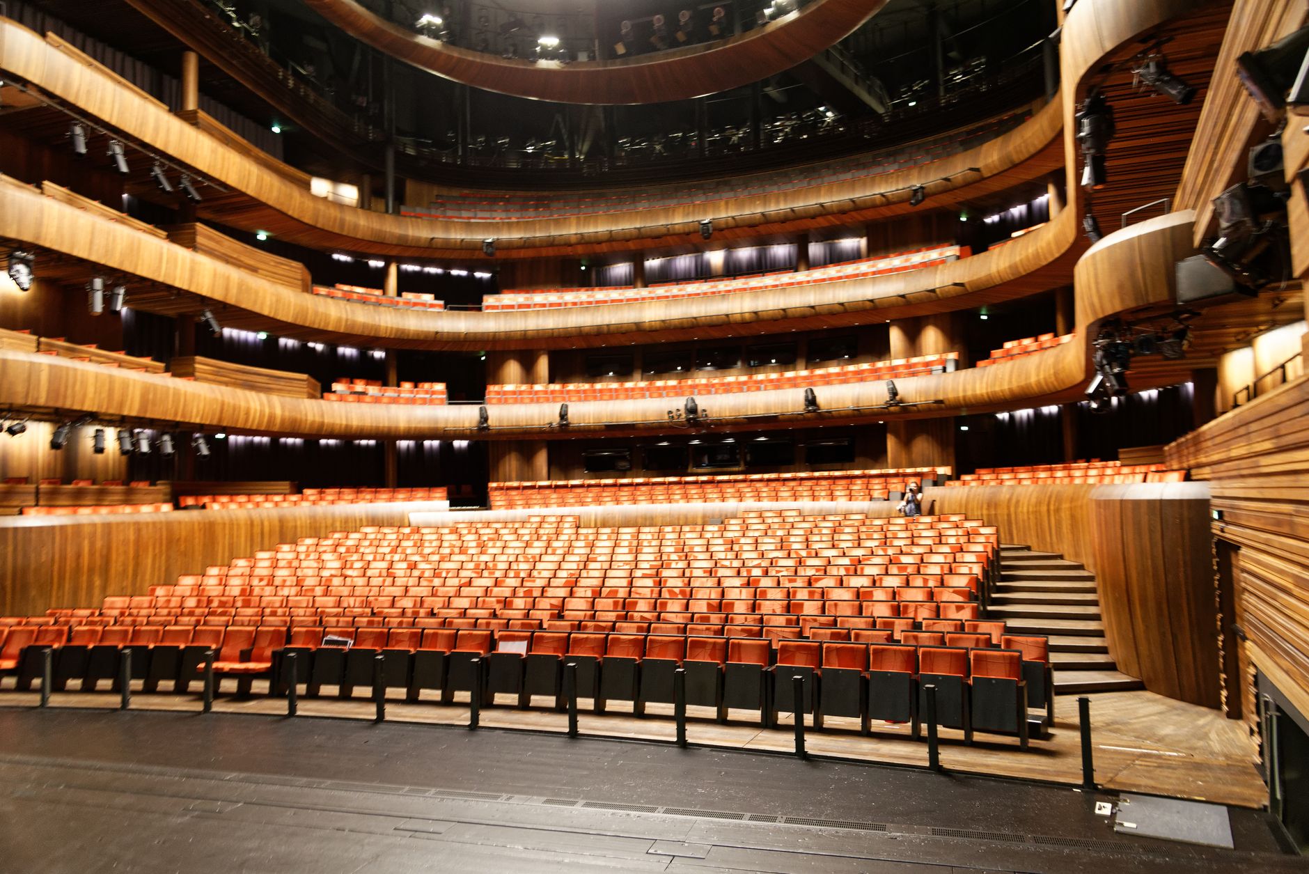 A spacious and modern indoor theatre featuring wooden interior and illuminated seating. — Trójmiasto