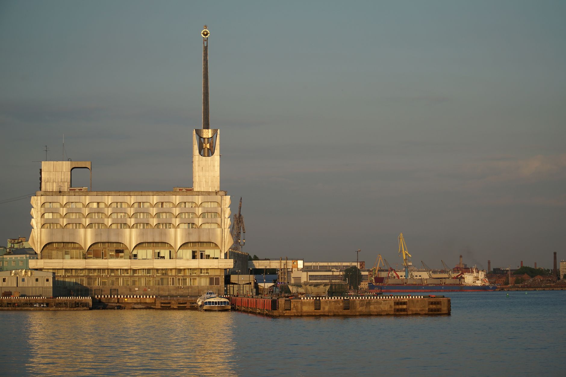 Striking modernist building at the harbor in Saint Petersburg, Russia, with cranes and ships. — Trójmiasto