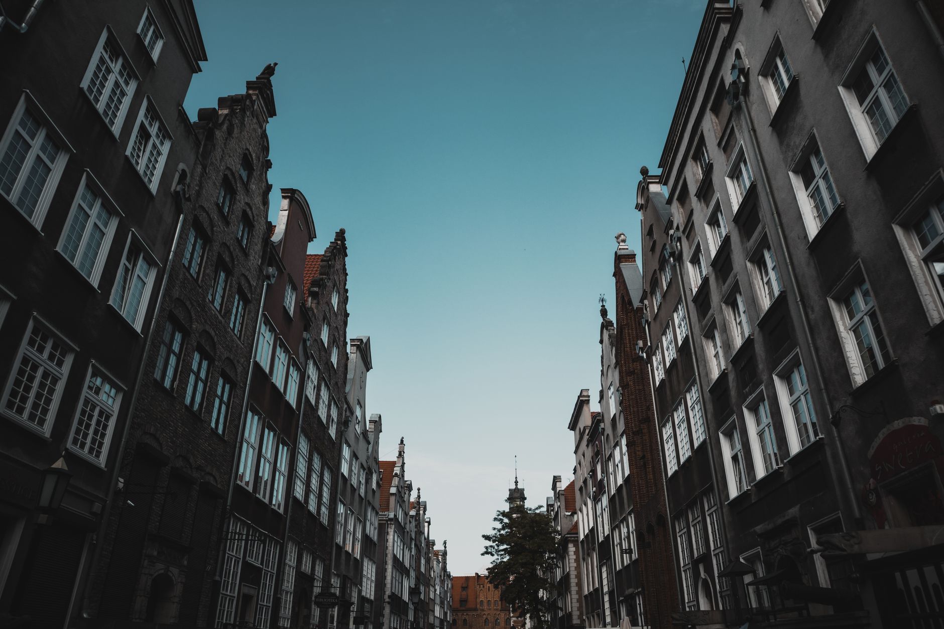 Capture of historic buildings along a street in Gdańsk, Poland under a clear sky. — Trójmiasto