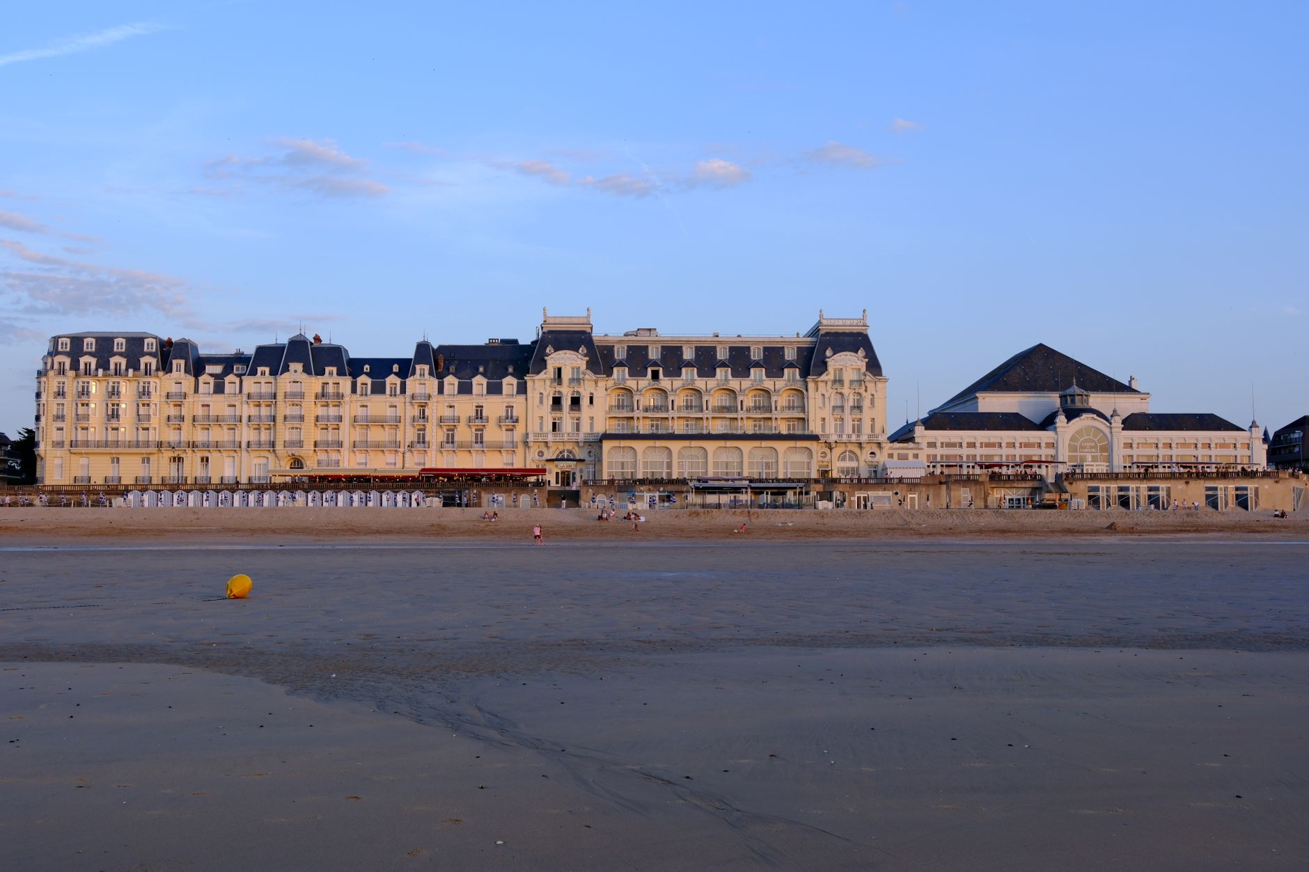 Elegant view of the Grand Hotel's facade on Cabourg Beach during sunset in Normandie, France. — Trójmiasto