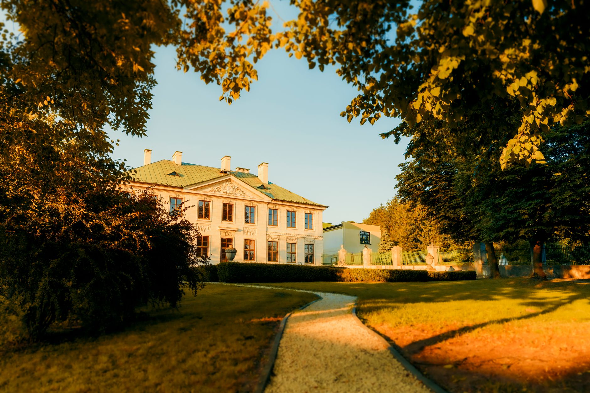 Charming view of the Wielkopolski Palace surrounded by sunlight and greenery in Pinczow, Poland. — Trójmiasto