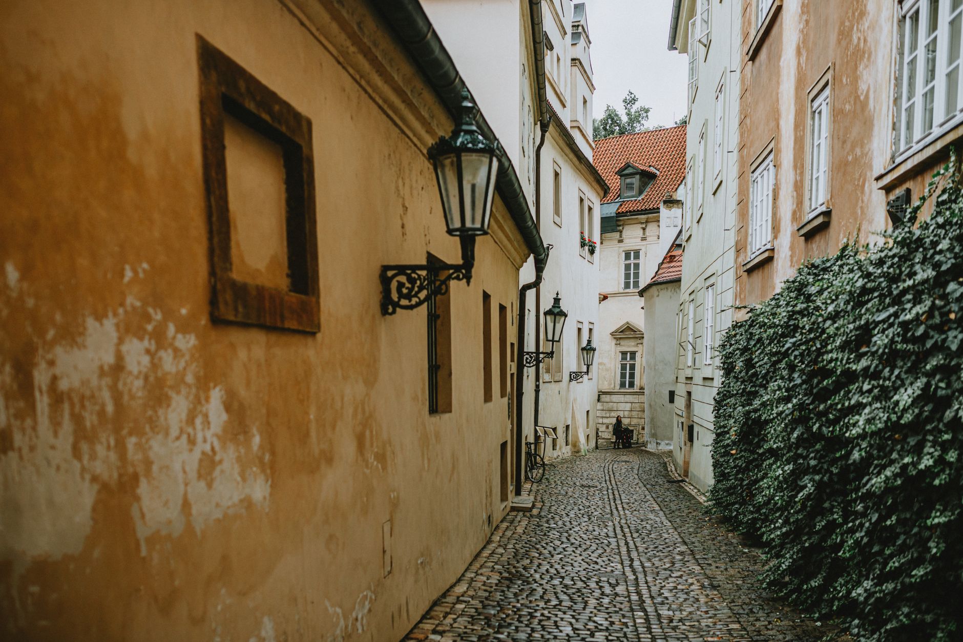 Explore a serene cobblestone alleyway with vintage street lamps in a picturesque European village. — Trójmiasto