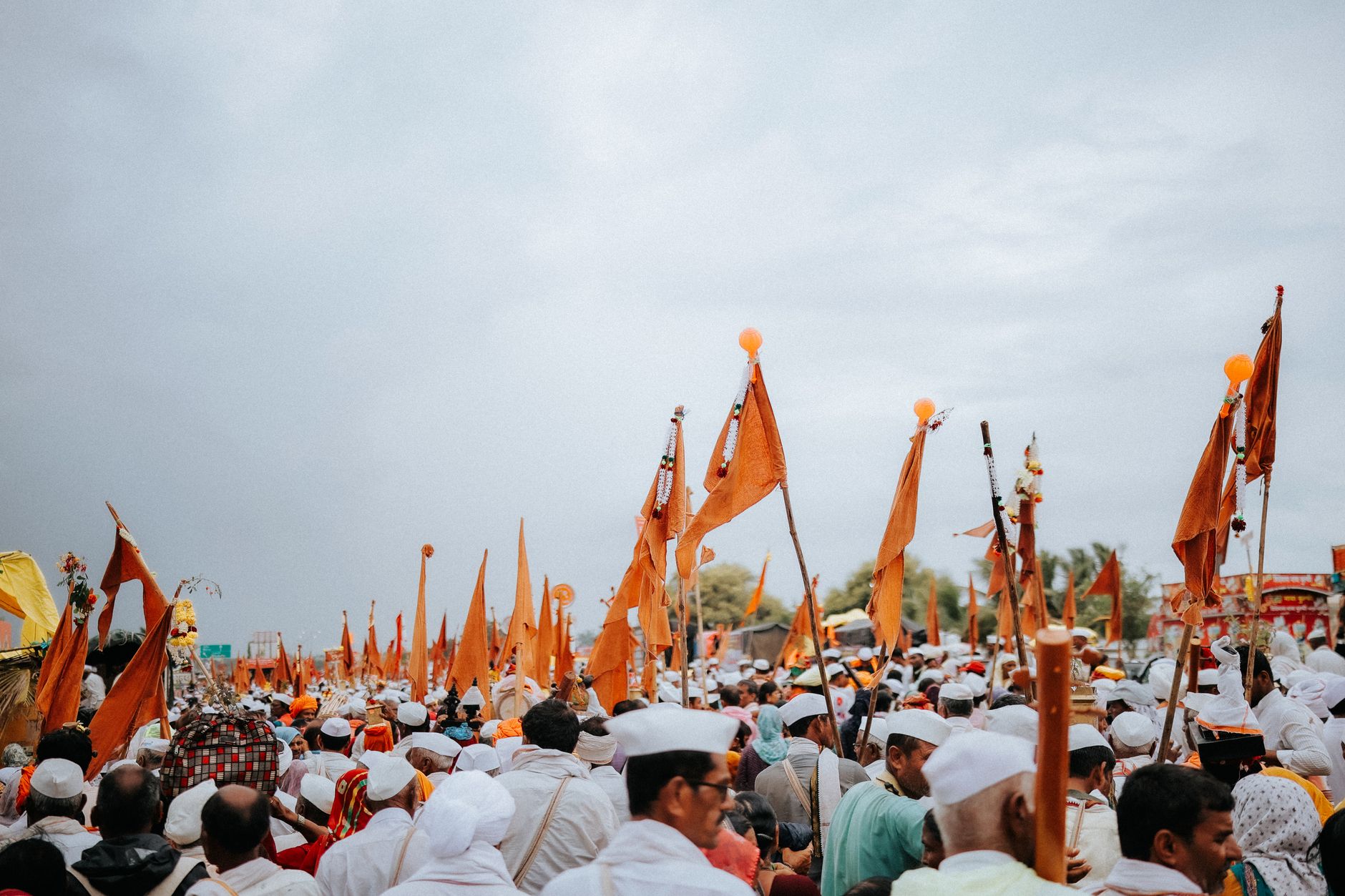 Colorful outdoor procession with a crowd holding orange flags, creating a festive atmosphere. — Trójmiasto